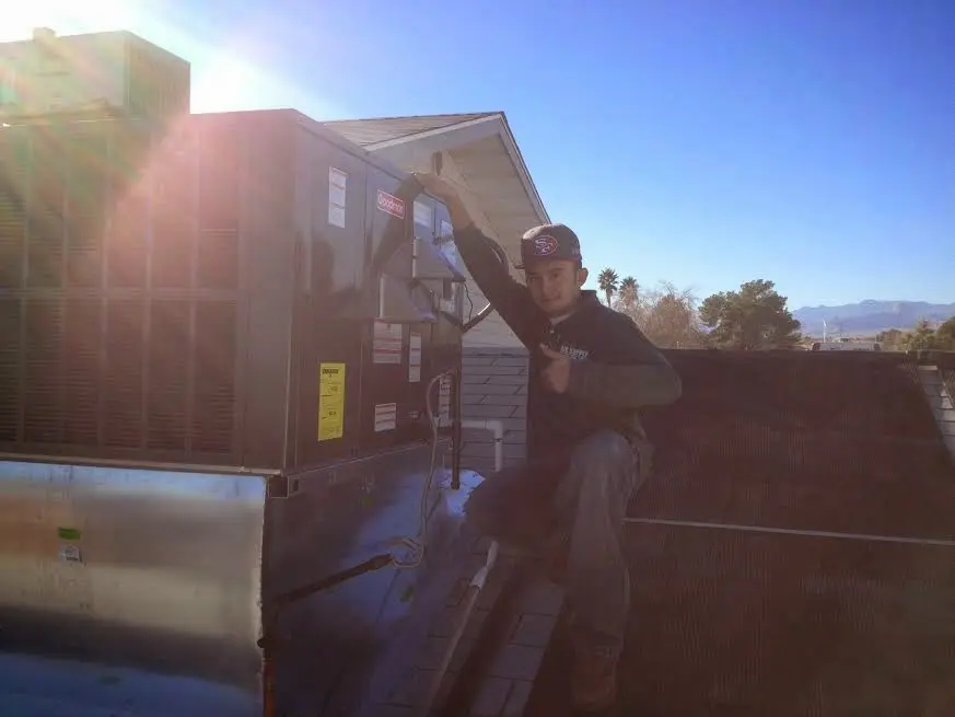 HVAC technician performing Air Duct Cleaning on a rooftop unit in Pittsfield